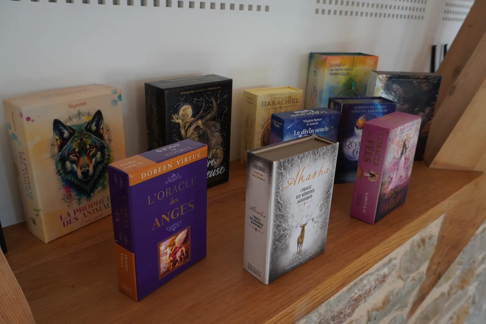 Jeux d'oracles alignés sur une étagère en bois du cabinet